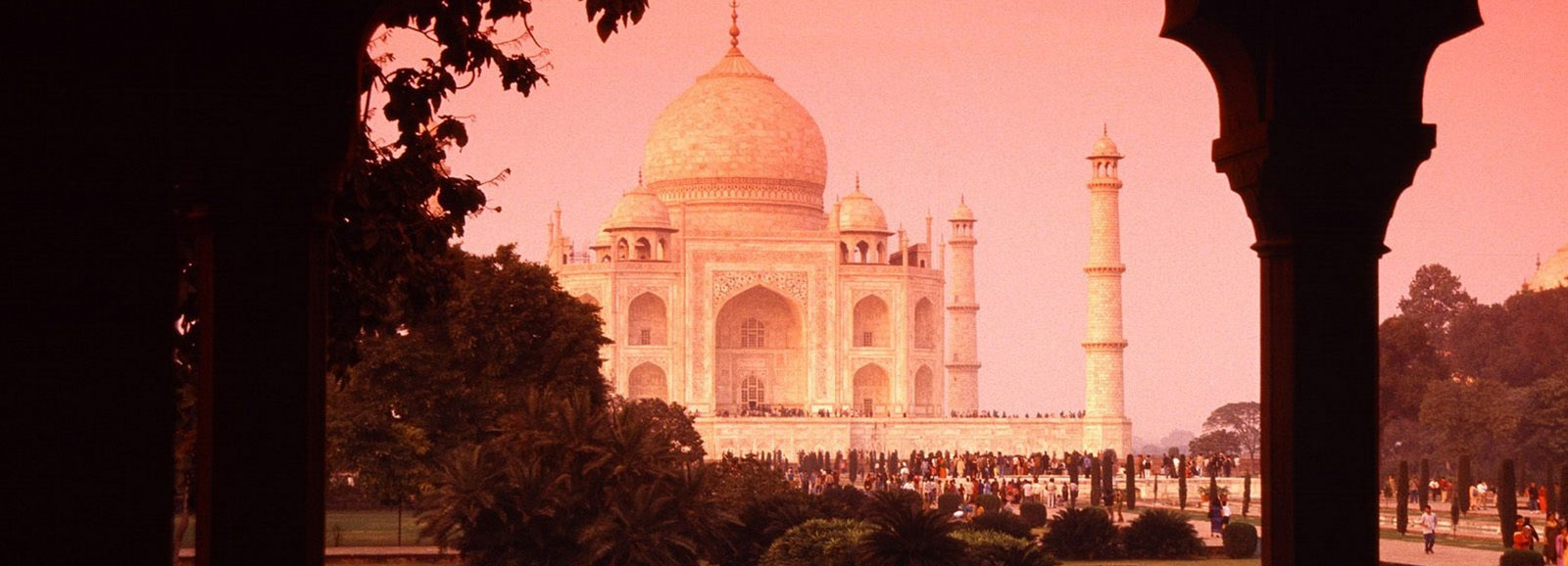The Taj Mahal at sunset, framed by a sandstone archway
